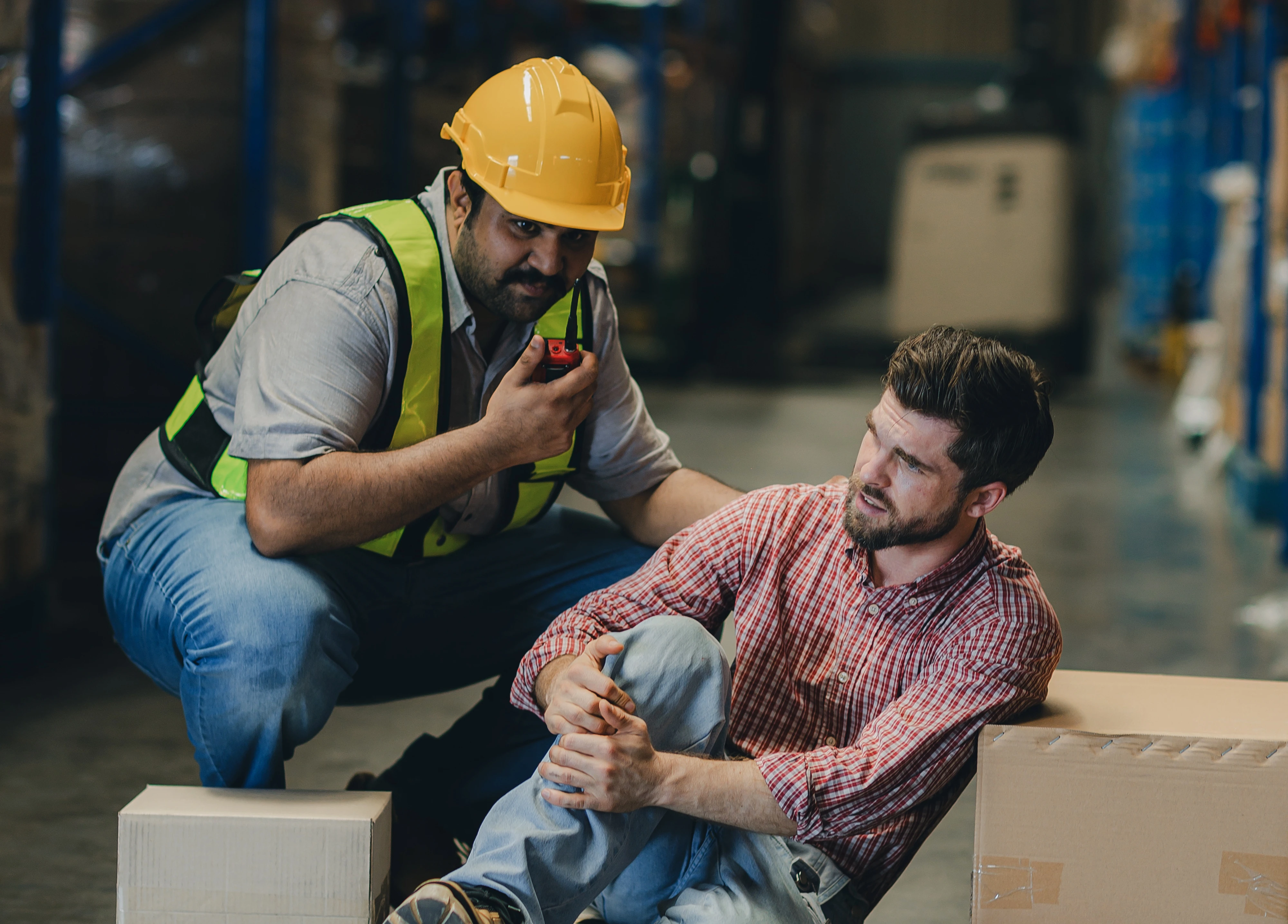 Injured warehouse worker being assisted by colleague
